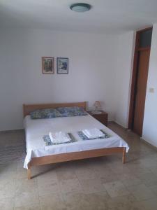 ein Schlafzimmer mit einem Bett in einem Zimmer in der Unterkunft Apartments Lončar in Novalja