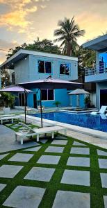 a house with a pool and a house with an umbrella at Kosta Brava Hotel y Restobar in El Majahual