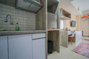 a kitchen with white cabinets and a sink at THE CABIN APARTMENT PATRALAND AMARTA in Kejayan
