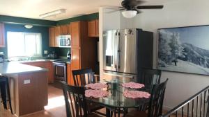 Una cocina con una mesa con sillas y un refrigerador. en your family home, en Aurora 6 fotos más