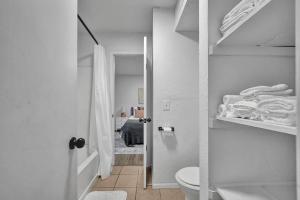 a white bathroom with a toilet and a bedroom at Near Boone Pickens Stadium - Stillwater Stay in Stillwater +29 photos