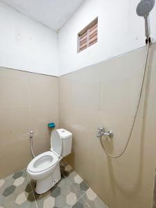 ein Badezimmer mit Toilette und Dusche in der Unterkunft Yan Loft in Uluwatu