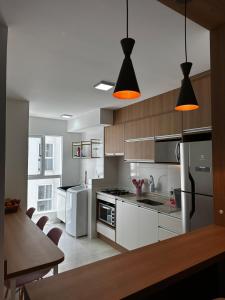 サンタ・マリアにあるApartment 603 Conforto e modernidade em cada detalheのキッチン(白い家電製品、茶色のキャビネット付)