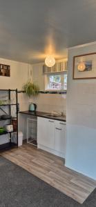 eine Küche mit weißen Schränken und einer Arbeitsplatte in der Unterkunft Ebony Cottage in Mangawhai