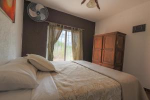 Un dormitorio con una cama, una ventana y un ventilador. en Cabañas La Ernestina, en Villa Carlos Paz
