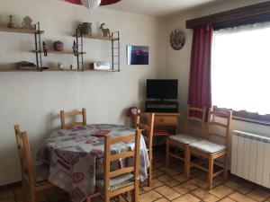 ein Zimmer mit Tisch und Stühlen und einem Fernseher in der Unterkunft Appartement skis aux pieds 6 pers, Le Praz de Lys - FR-1-815-11 in Le Praz de Lys
