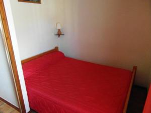 ein rotes Bett in einer Ecke des Zimmers in der Unterkunft Appartement skis aux pieds 6 pers, Le Praz de Lys - FR-1-815-11 in Le Praz de Lys