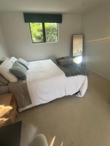 ein Schlafzimmer mit großem Bett und Fenster in der Unterkunft Myrtle St Guesthouse in Auckland