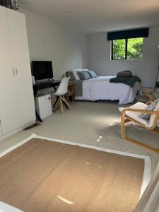 ein Schlafzimmer mit einem Bett und einem Schreibtisch mit einem Computer in der Unterkunft Myrtle St Guesthouse in Auckland + 3 Fotos