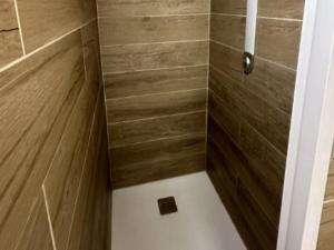 Le LandinにあるMobil Home 27m² avec Terrasse à Jumièges - API-1-52-834の木製の壁とシャワー付きのバスルーム