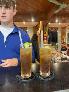 a man sitting at a counter with two drinks at Mai Chau Hostel in Mai Châu +28 photos