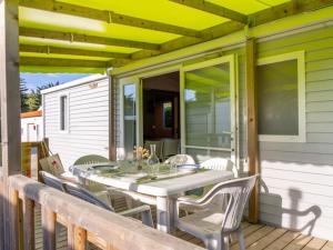 a white table and chairs on a porch at Mobil-home Adapté PMR avec Terrasse à Notre-Dame-de-Monts - API-1-52-664 in Notre-Dame-de-Monts
