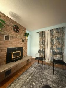 a living room with a fireplace and two chairs at Cozy Belleville Retreat Near DT & Waterfront in Belleville