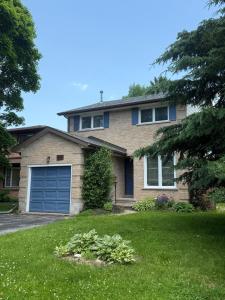 a house with a blue garage door in a yard at Cozy Belleville Retreat Near DT & Waterfront in Belleville