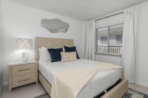a white bedroom with a bed and a window at The Naples Beach Retreat in Naples +22 photos