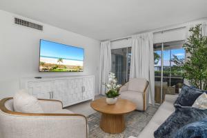 a living room with a tv on a wall at The Naples Beach Retreat in Naples