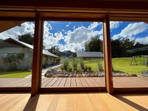 a view of a garden through a sliding glass door at ヴィラグリファーム七里岩 in Nirasaki