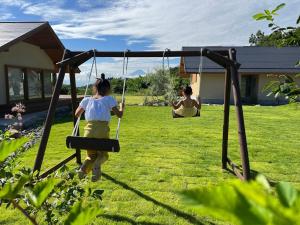 a girl on a swing in a yard at ヴィラグリファーム七里岩 in Nirasaki