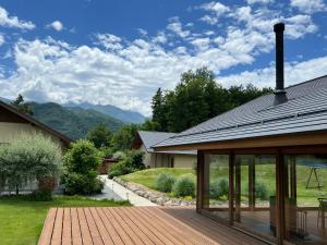 a house with a deck with a view of the mountains at ヴィラグリファーム七里岩 in Nirasaki