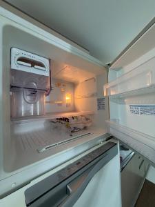 an empty refrigerator with its door open with its door at Apartment in Brava, 950m from the sea! in Itajaí