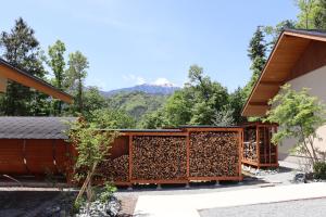 a house constructed from wood with mountains in the background at ヴィラグリファーム七里岩 in Nirasaki