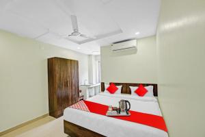 a bedroom with a large bed with red pillows at Hotel O VRK Residency in Visakhapatnam +20 photos