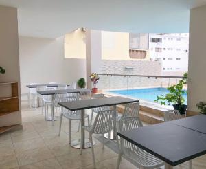 a restaurant with tables and chairs and a swimming pool at Hotel Arena Blanca in Salinas