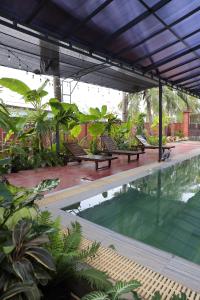 a group of benches sitting next to a swimming pool at Pun House in Phan Thiet