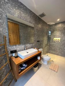 ein Badezimmer mit Waschbecken und Toilette in der Unterkunft Bali Taoka Villa Tanah Lot in Tanah Lot + 18 Fotos