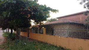 a fence in front of a building with a tree at Casa Argentina in Limpio