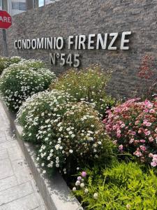 ein Schild für den Eingang zu einem Gebäude mit Blumen in der Unterkunft Departamento cerca de la Playa in La Serena