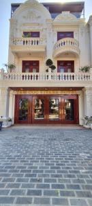 un grand bâtiment avec des portes et une cour en pierre dans l'établissement Tam Coc Vivana Hotel, à Ninh Binh