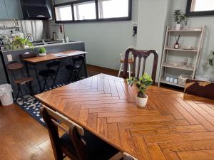 Cette chambre comprend une grande table en bois et une cuisine. dans l'établissement 石垣島グループの宿 2216 にじいろ ユーグレナモール内, à Ishigaki 60 autres photos