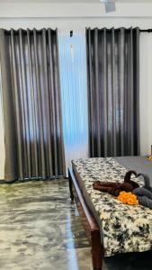 ein Schlafzimmer mit einem Bett und einem Fenster mit Vorhängen in der Unterkunft Taprobana Island Bliss in Dikwella