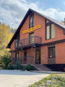 ein rotes Backsteingebäude mit einem Hotelschild darauf in der Unterkunft Zhaily Sai Resort, in Zhezdi