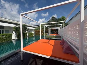 a house with a swimming pool with an orange and white deck at Phangan Hometown Resort - Adults Only in Ban Tai
