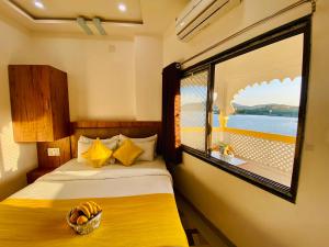 a bedroom with a bed and a large window at Hotel Vallabh at Pichola Lake Nathi Ghat Brahmpole Udaipur in Udaipur