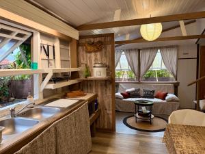 a kitchen with a sink and a living room at Faaora Lodge, little paradise Moorea in Haapiti