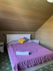 ein Bett mit einer lila Decke und zwei Kissen darauf in der Unterkunft Zhaily Sai Resort, in Zhezdi + 16 Fotos
