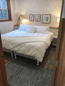 a bedroom with a large bed with white sheets at Brighton guest suite in Boston