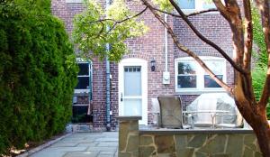 a brick house with a white door and chairs on a porch at Brighton guest suite in Boston