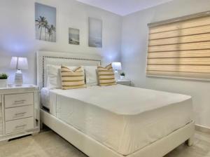 1 dormitorio blanco con 1 cama blanca grande con almohadas en Vista Colonial, en Calero