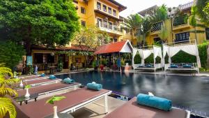 a hotel swimming pool with a bunch of beds in it at Villa Indochine d'Angkor in Siem Reap