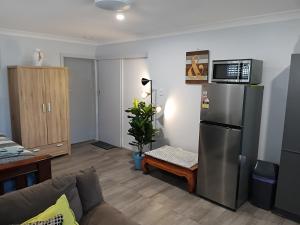 een woonkamer met een koelkast en een bank bij Bonnys Bliss in Bonny Hills +15 foto's