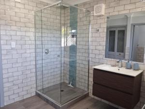een glazen douche in een badkamer met een wastafel bij Bonnys Bliss in Bonny Hills