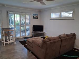 een woonkamer met een bank en een flatscreen-tv bij Bonnys Bliss in Bonny Hills