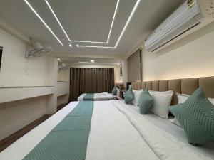 um quarto de hotel com uma cama grande e um sofá em Hotel Anantshree Inn Shree Mahakaleshwar Temple Ujjain em Ujjain