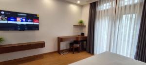 Cette chambre comprend un bureau et une télévision murale. dans l'établissement Tam Coc Vivana Hotel, à Ninh Binh 12 autres photos