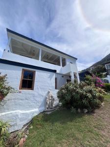 a white house with a window on the side of it at Pearlfields House Kalk Bay in Kalk Bay