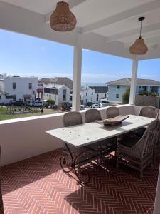 a white table and chairs on a patio with a view at Pearlfields House Kalk Bay in Kalk Bay